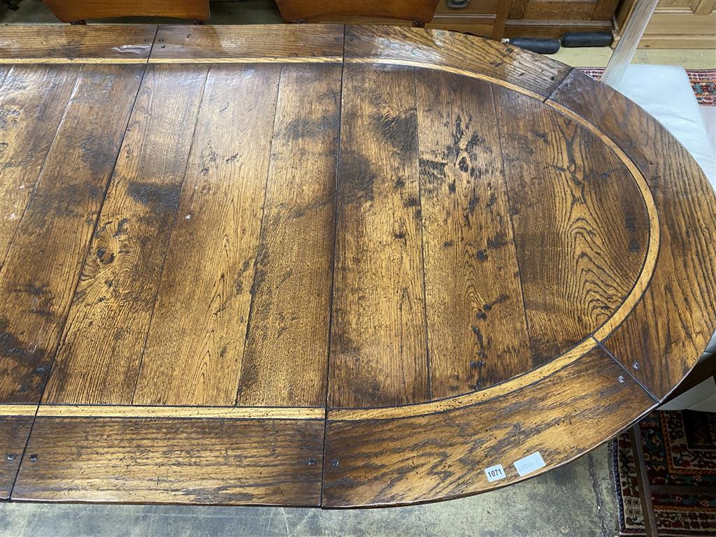 An 18th century style cross banded oak D end twin pillar extending dining table, 284cm extended, two spare leaves, width 130cm, height